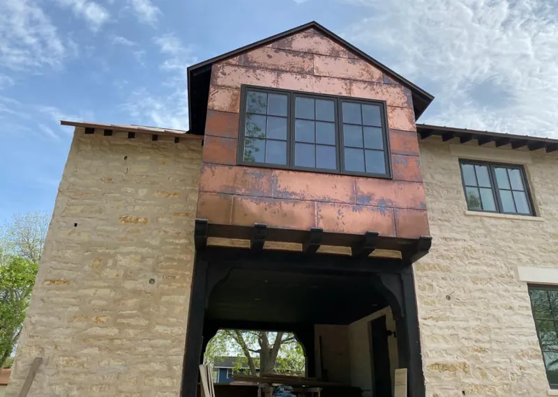 Copper metal panel facade on a stone building for Skylight Installation in Garden City